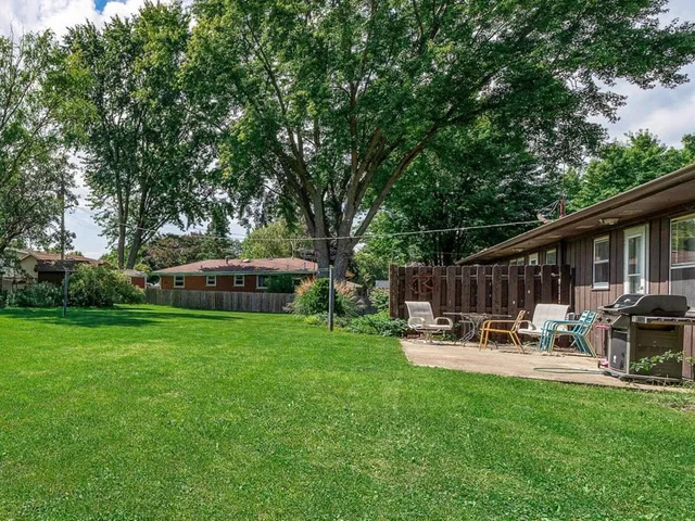 a backyard of a house with garden table and chairs