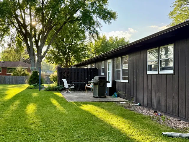 a front view of a house with garden and trees