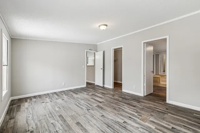 a view of an empty room with wooden floor