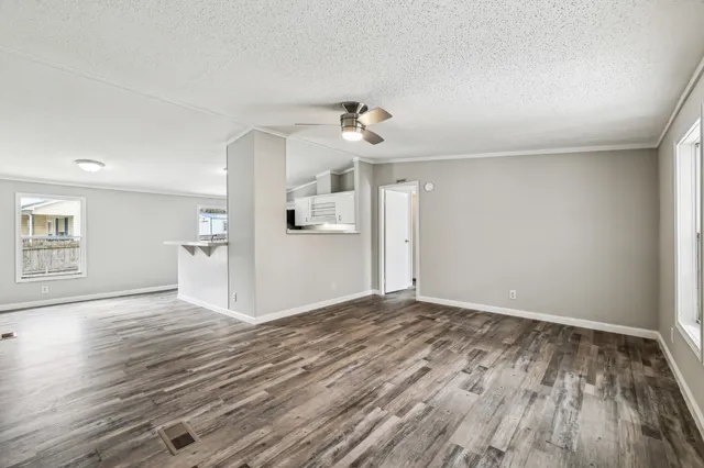 a view of empty room with wooden floor and ceiling fan