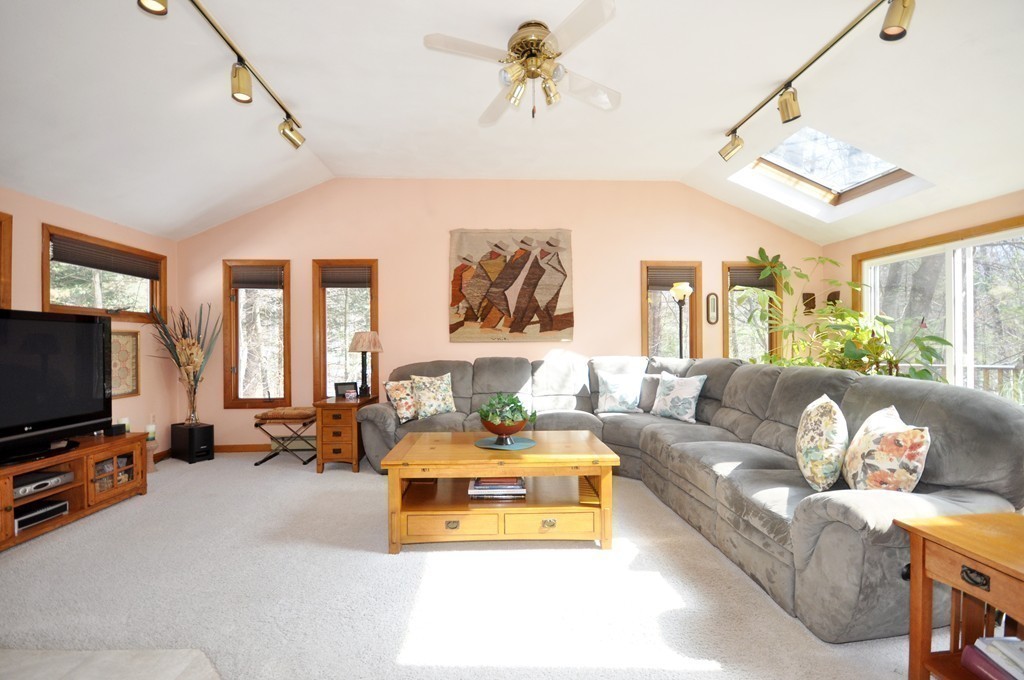 174 Hudson Road Stow, MA 01775 - Photo 8 of 29 a living room with furniture gym equipment and a flat screen tv