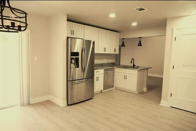 a kitchen with a refrigerator sink and cabinets
