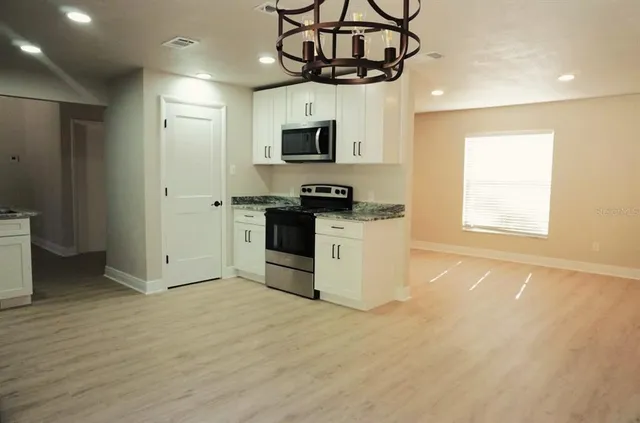 a kitchen with stainless steel appliances granite countertop a stove and a microwave