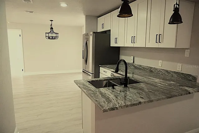 a kitchen with stainless steel appliances a refrigerator and a stove top oven