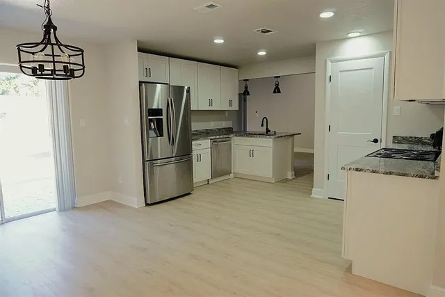 a kitchen with stainless steel appliances a refrigerator and a stove top oven
