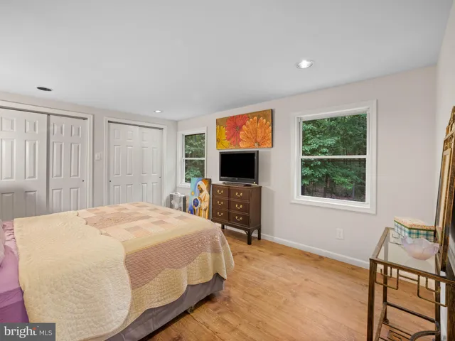 a spacious bedroom with a bed and a flat screen tv