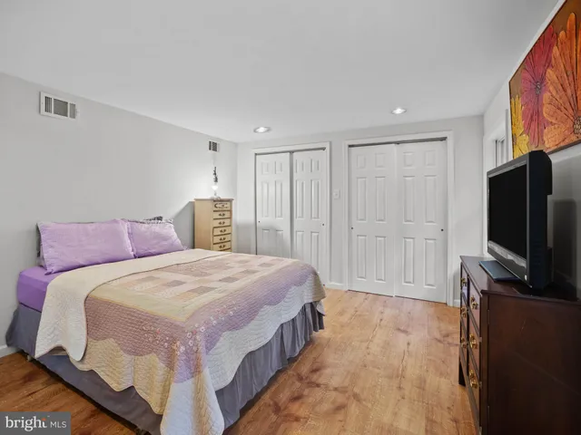 a spacious bedroom with a bed and a flat screen tv