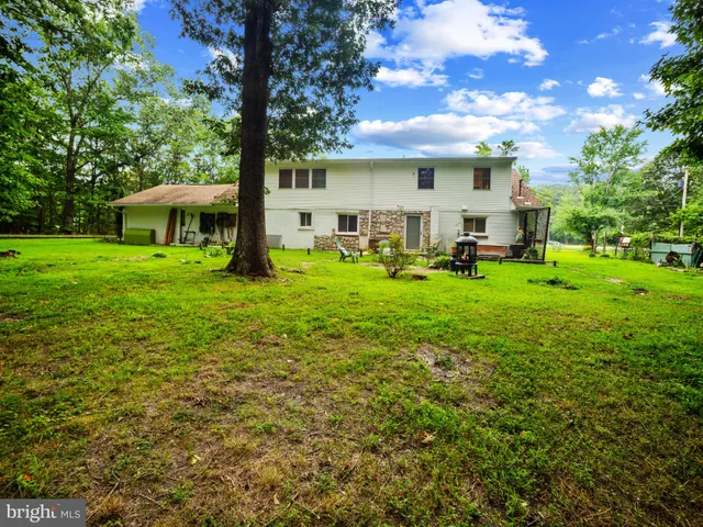 a view of a house with backyard and sitting area