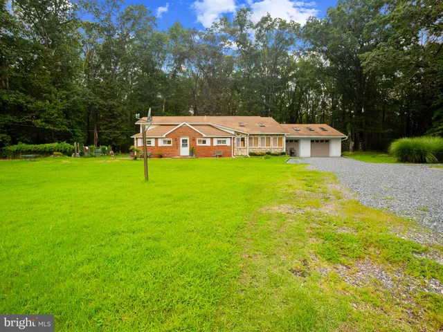 a front view of a house with a garden and yard