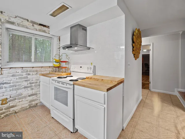a kitchen with a stove and a wooden floors