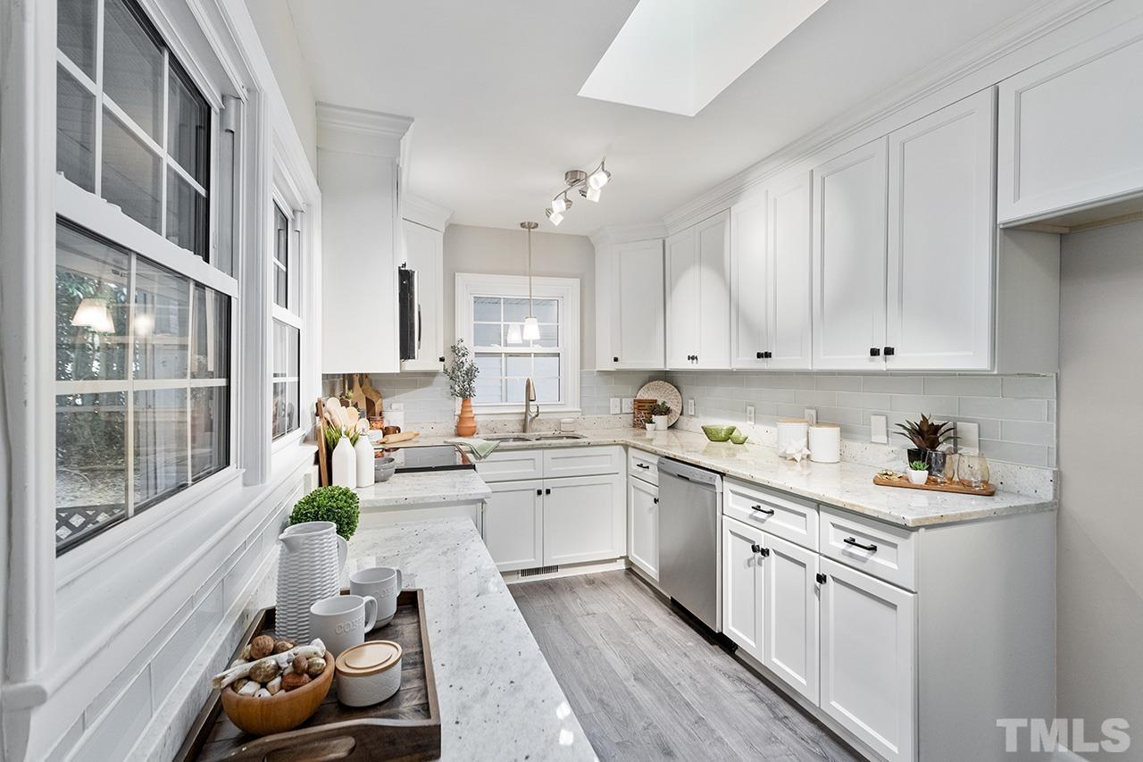 a kitchen filled with white cabinets and white appliances
