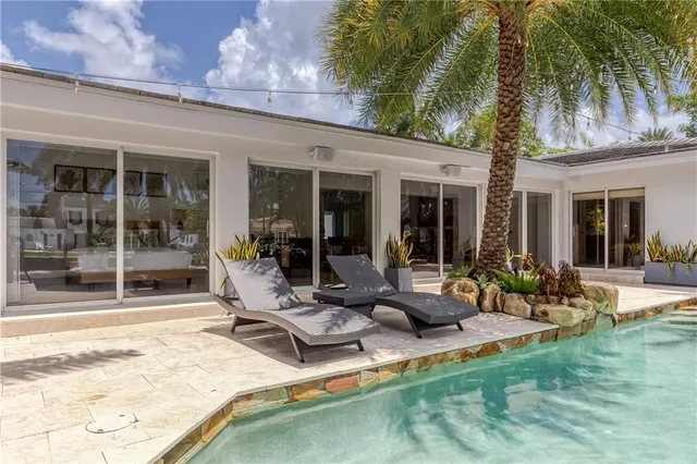 a house with a swimming pool and outdoor seating