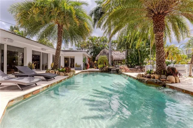 a view of a house with swimming pool and sitting area