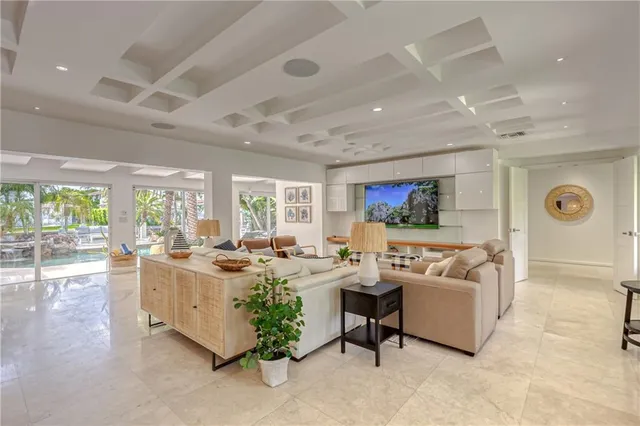 a room with lots of white furniture and a floor to ceiling window