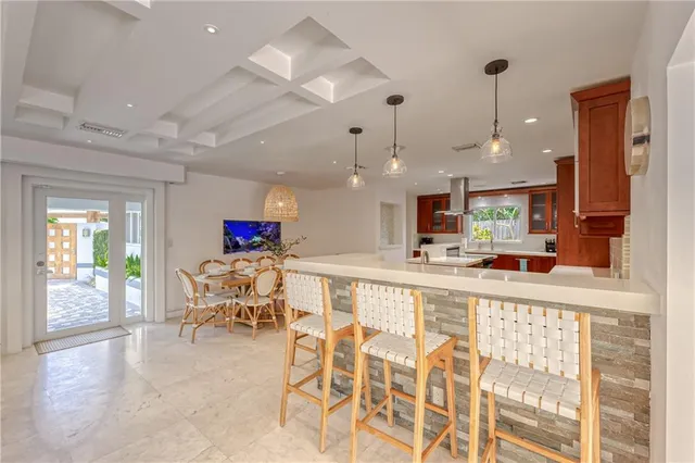 a view of a dining room and livingroom with furniture wooden floor a chandelier