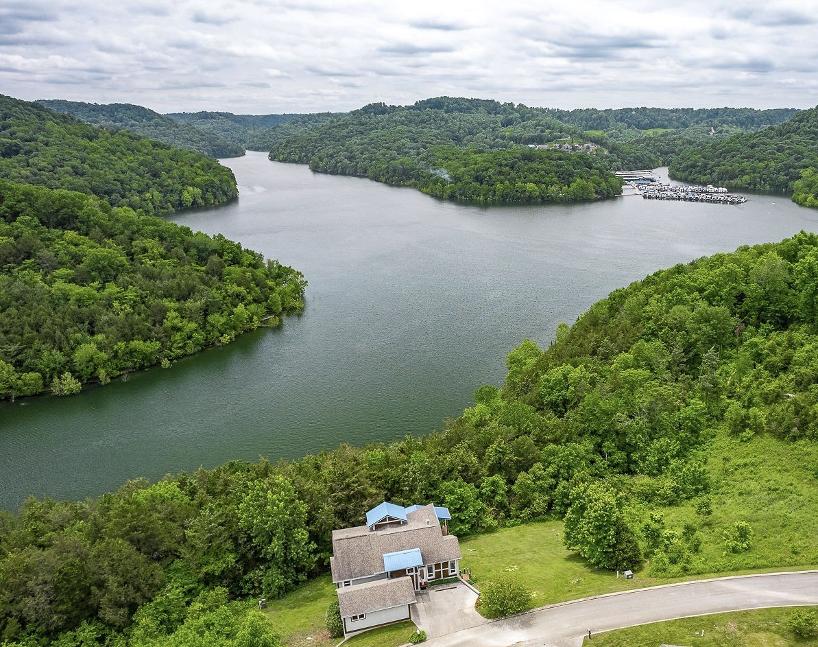an aerial view of a house with a yard and lake view