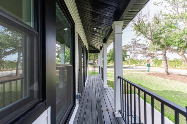 a view of a porch with wooden floor in front of house