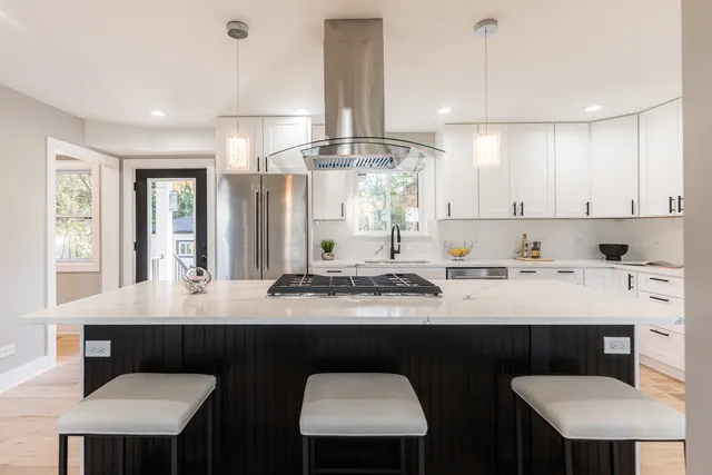 a kitchen with stainless steel appliances a sink and a table