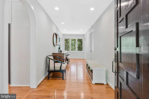a kitchen with stainless steel appliances granite countertop a dining table chairs stove refrigerator and cabinets