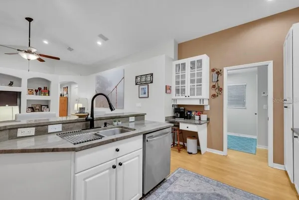 a living room with furniture kitchen view and a chandelier