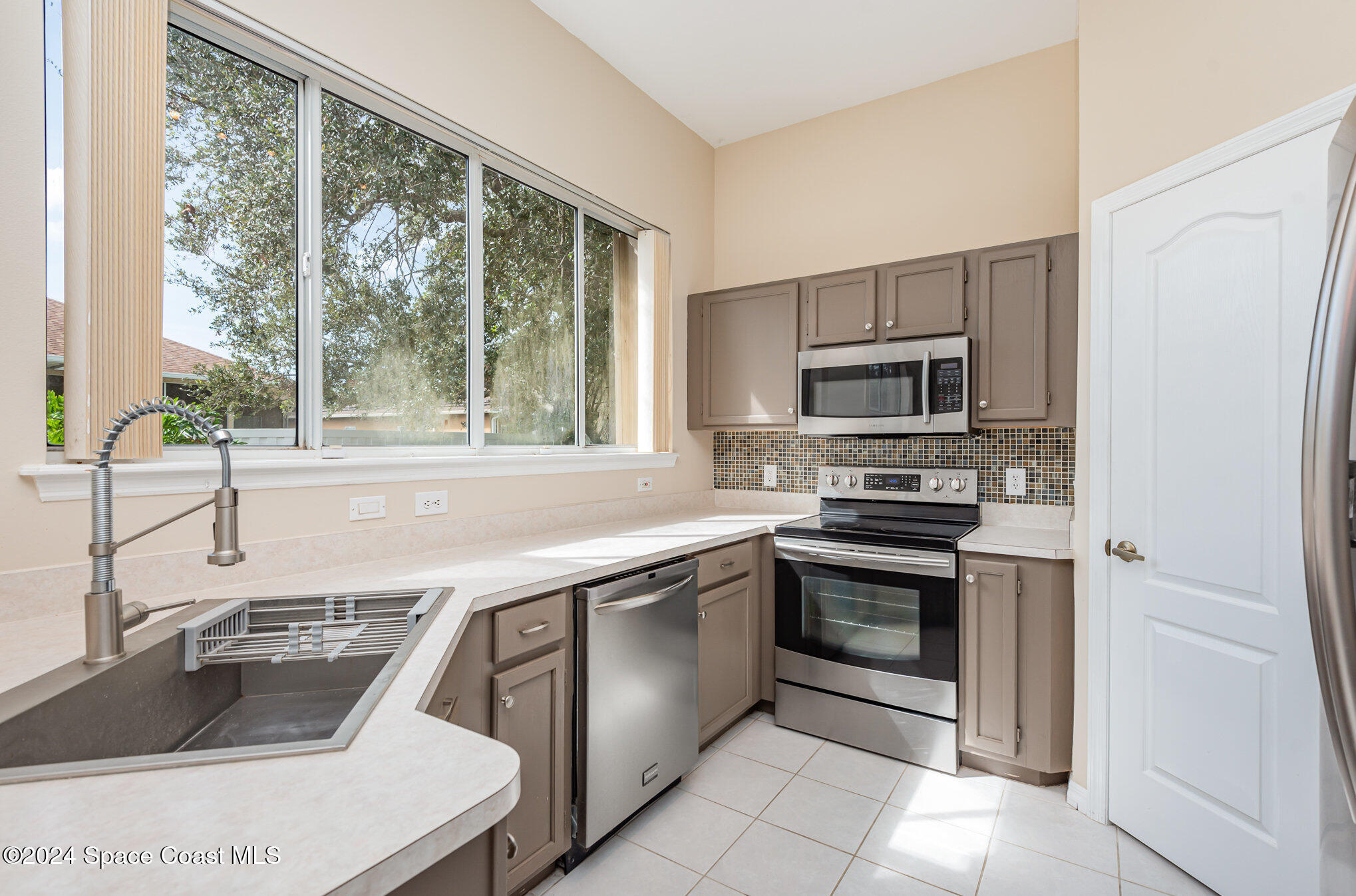779 Thrasher Drive Rockledge, FL 32955 - Photo 12 of 35 a kitchen with a sink stove and microwave