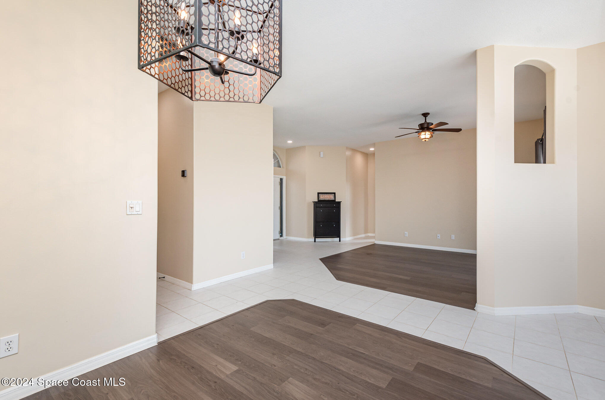 779 Thrasher Drive Rockledge, FL 32955 - Photo 15 of 35 a view of a hallway with wooden floor and a chandelier