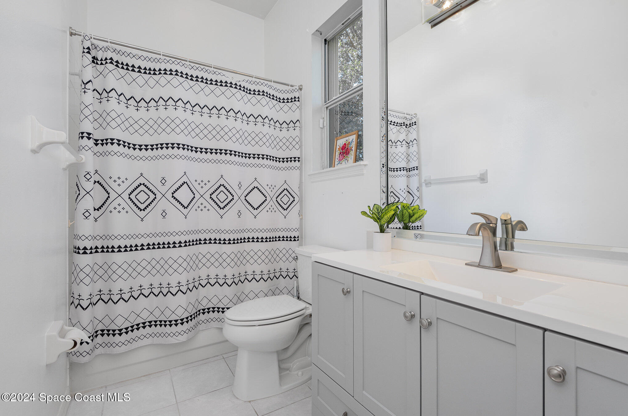 779 Thrasher Drive Rockledge, FL 32955 - Photo 21 of 35 a bathroom with a granite countertop sink a toilet and a mirror