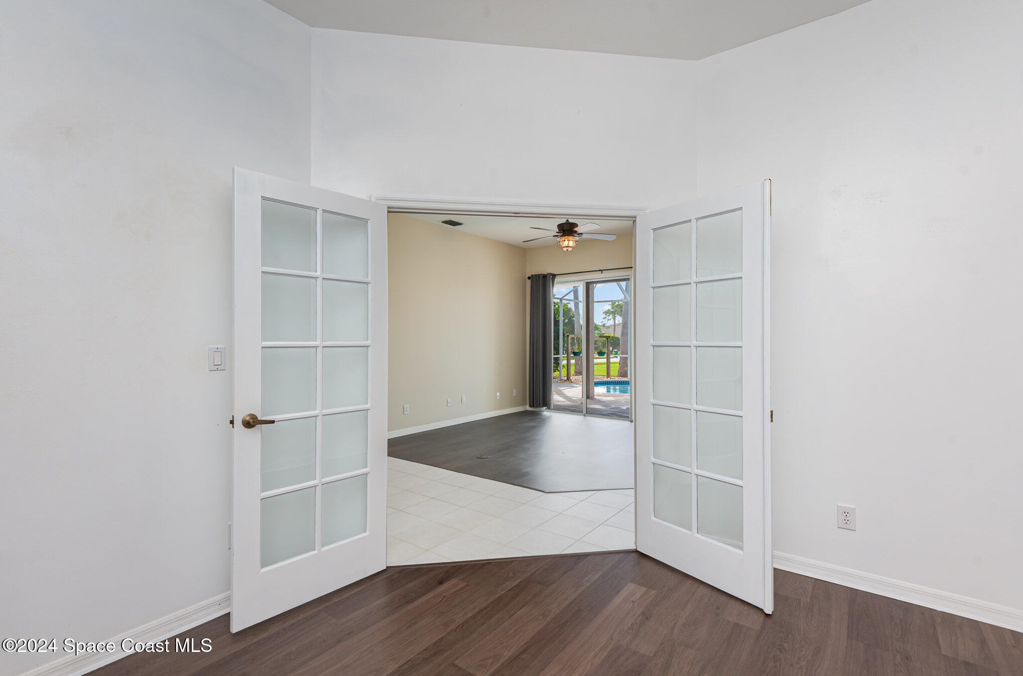 779 Thrasher Drive Rockledge, FL 32955 - Photo 24 of 35 an empty room with wooden floor and windows