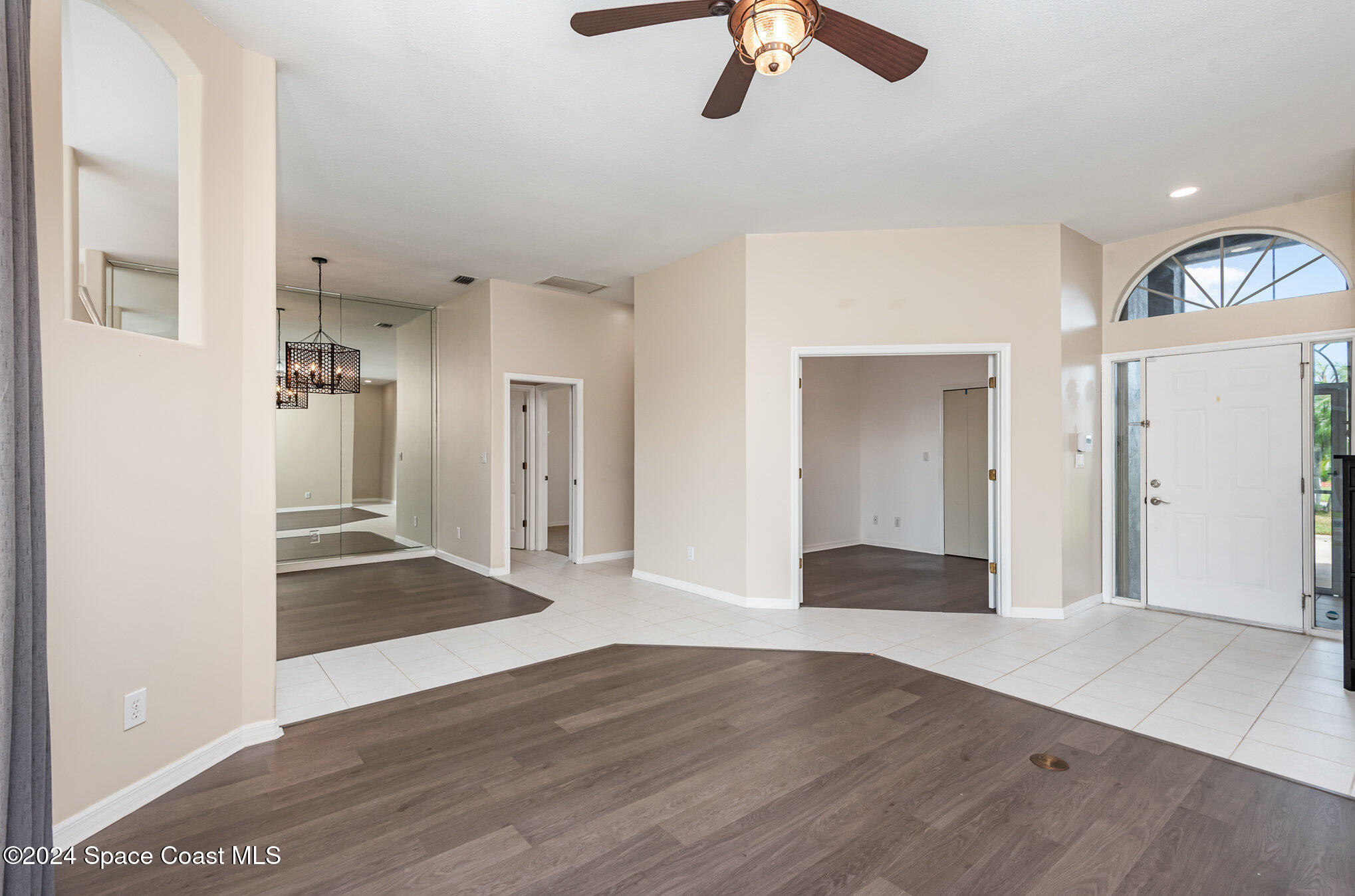 779 Thrasher Drive Rockledge, FL 32955 - Photo 9 of 35 a view of a hallway with wooden floor and chandelier