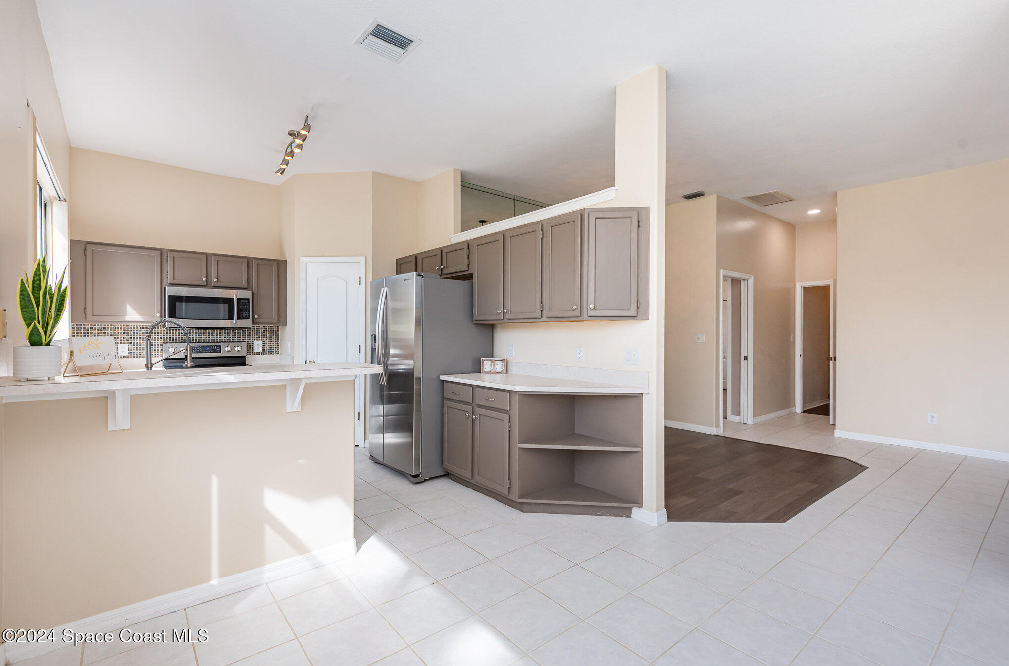779 Thrasher Drive Rockledge, FL 32955 - Photo 10 of 35 a kitchen with stainless steel appliances kitchen island sink refrigerator and microwave