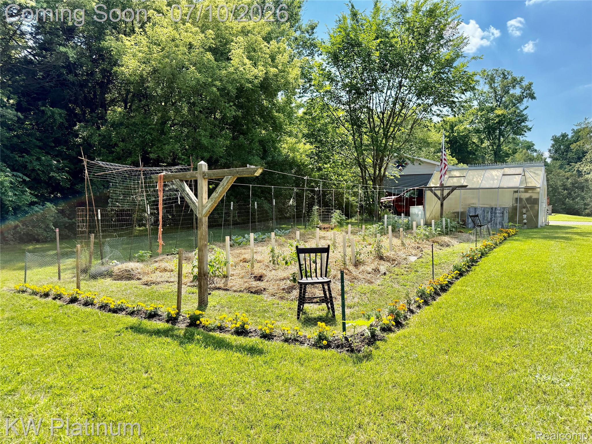 1581 Emerson Road Goodells, MI 48027 - Photo 30 of 45 Expansive lawn with a dedicated garden area featuring a trellis system and a greenhouse structure