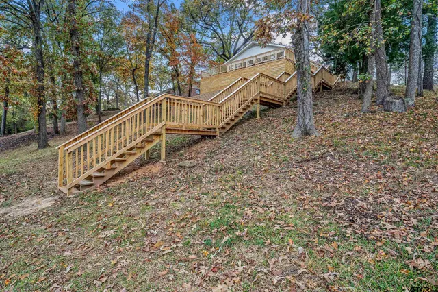 a view of a house with backyard and trees
