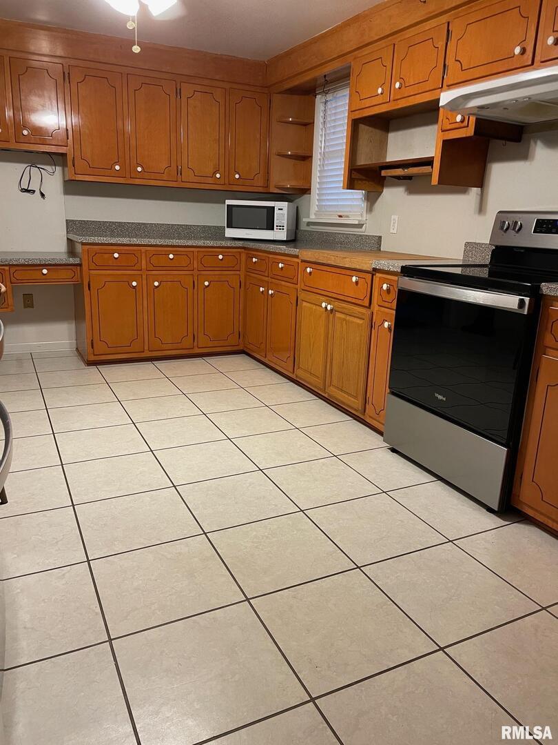 901 Elm Street Carmi, IL 62821 - Photo 5 of 21 a kitchen with stainless steel appliances granite countertop a stove a sink and a microwave