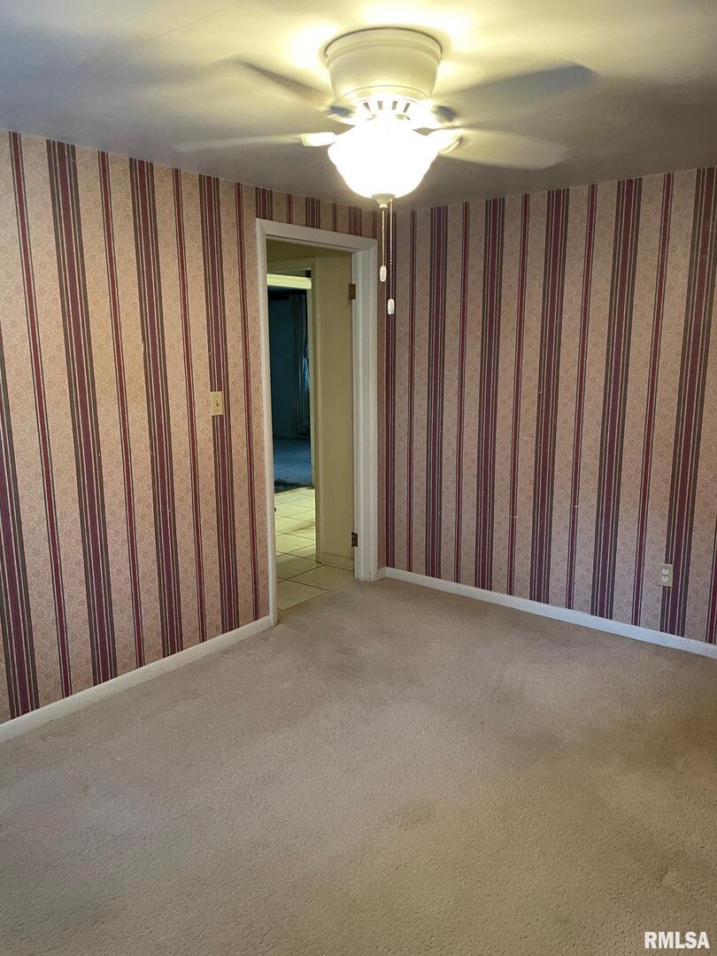 901 Elm Street Carmi, IL 62821 - Photo 8 of 21 a view of a hallway with a chandelier fan and wooden floor