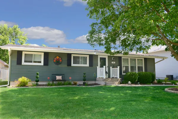 a front view of a house with a garden and yard