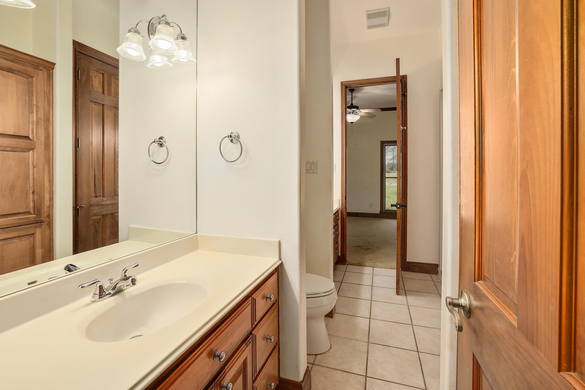 3900 Shell Road Georgetown, TX 78628 - Photo 24 of 40 Bathroom featuring vanity, light tile patterned floors, ceiling fan, and a chandelier