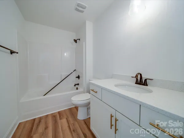 a bathroom with a granite countertop sink toilet a mirror and shower