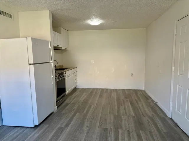 a view of a refrigerator in kitchen and wooden floor