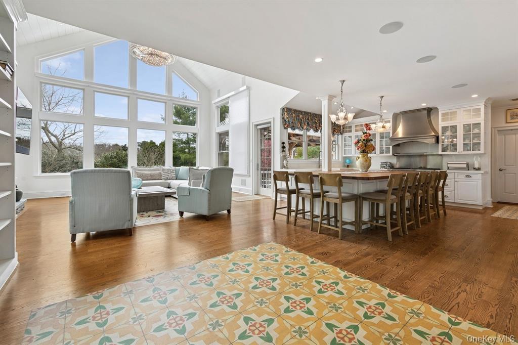 15 Carter Road Hampton Bays, NY 11946 - Photo 11 of 47 Dining space with a chandelier, dark wood-type flooring, built in shelves, a high ceiling, and recessed lighting