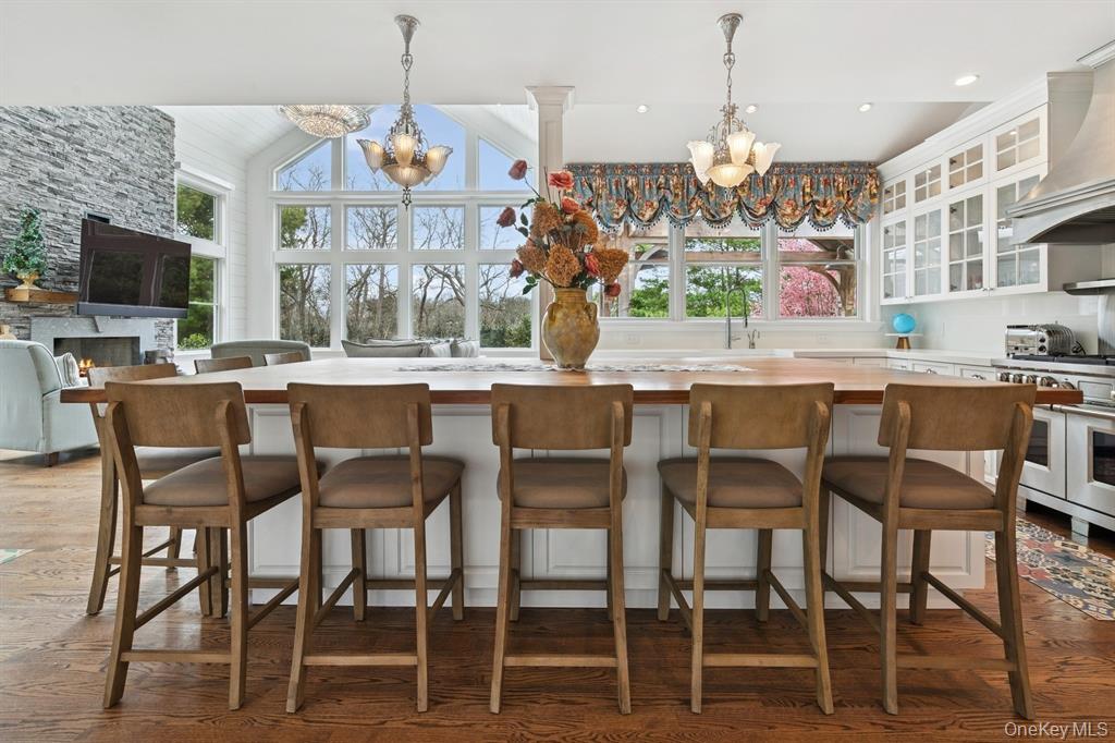 15 Carter Road Hampton Bays, NY 11946 - Photo 15 of 47 Kitchen with glass insert cabinets, wood counters, pendant lighting, a chandelier, and white cabinets