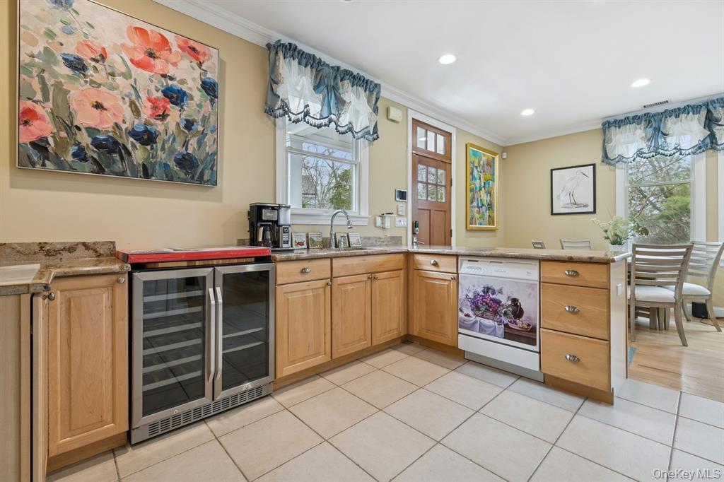 15 Carter Road Hampton Bays, NY 11946 - Photo 21 of 47 Bar area with light stone counters, beverage cooler, white dishwasher, crown molding, and healthy amount of natural light