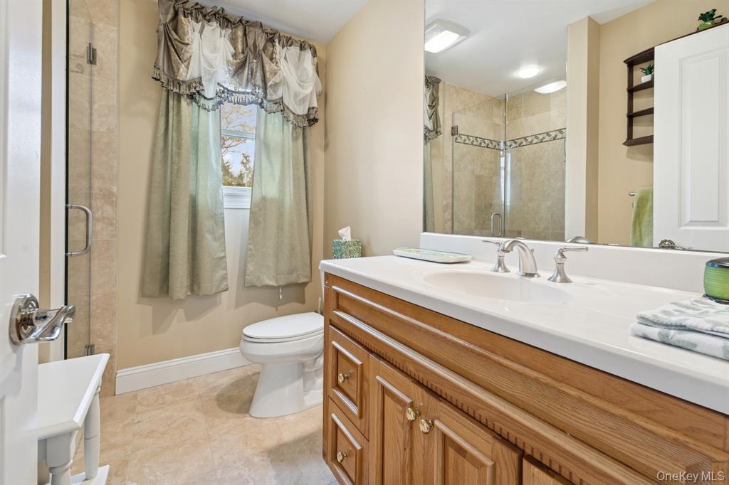 15 Carter Road Hampton Bays, NY 11946 - Photo 23 of 47 Bathroom featuring vanity, a shower stall, and light tile patterned flooring