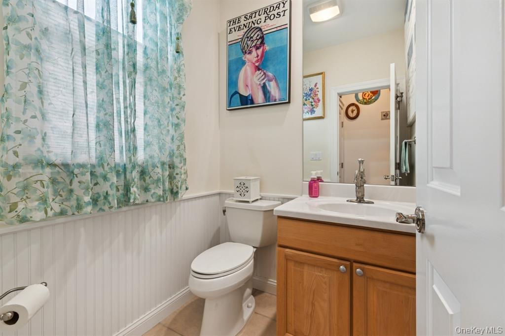 15 Carter Road Hampton Bays, NY 11946 - Photo 24 of 47 Bathroom with vanity, a wainscoted wall, and light tile patterned flooring