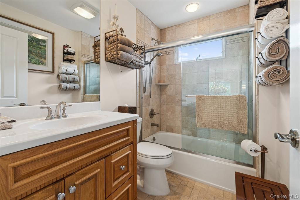 15 Carter Road Hampton Bays, NY 11946 - Photo 28 of 47 Bathroom with combined bath / shower with glass door, vanity, and stone finish floors