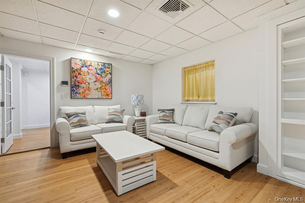 15 Carter Road Hampton Bays, NY 11946 - Photo 34 of 47 Living area with a paneled ceiling, light wood-type flooring, and built in shelves