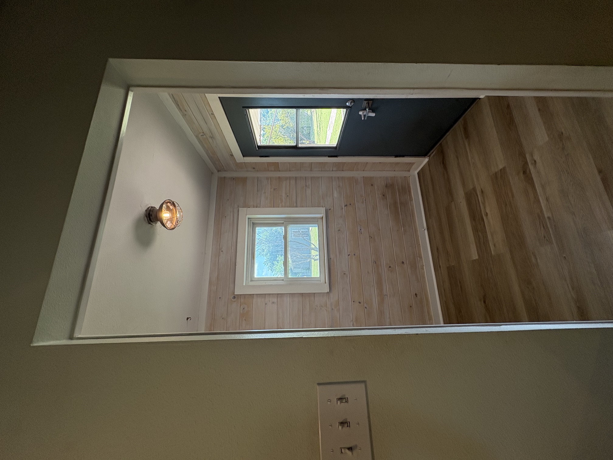 9032 Nuckols Crossing Road Austin, TX 78744 - Photo 7 of 14 Mudroom with natural wood paneling and durable flooring, illuminated by a decorative light fixture.