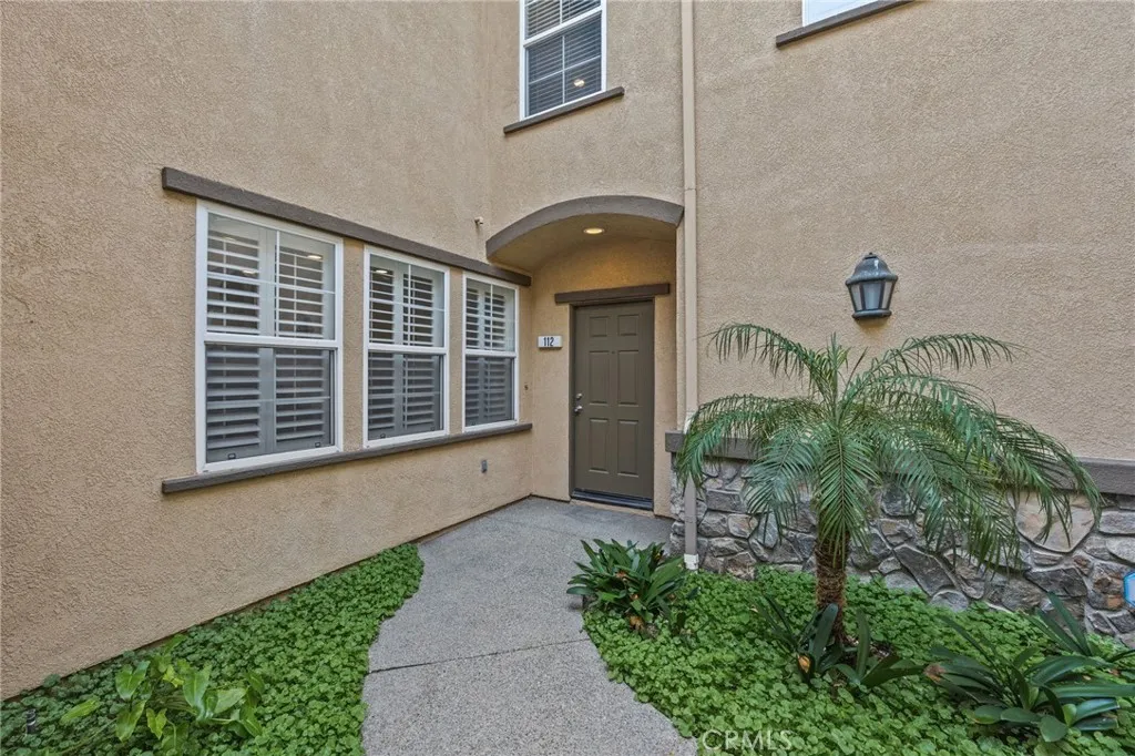 7353 Ellena West Street West, Unit 112 Rancho Cucamonga, CA 91730 - Photo 4 of 38 a front view of a house with a yard