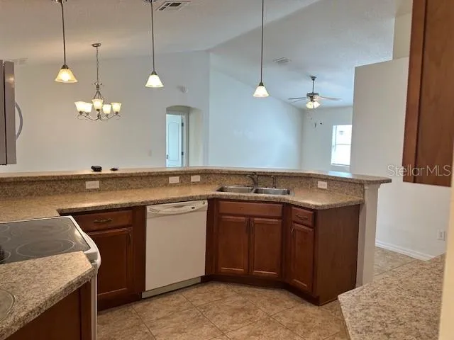 a view of a kitchen with a sink and chandelier