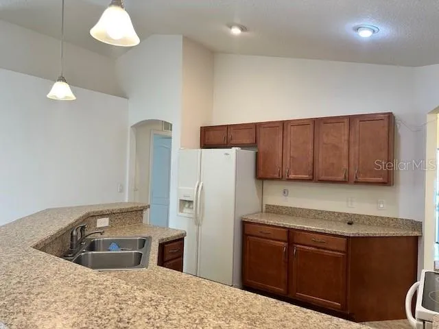 a kitchen with stainless steel appliances granite countertop a sink a refrigerator and a stove