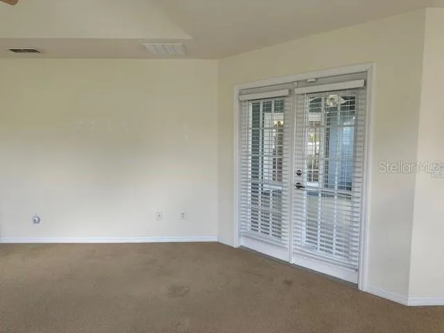 an empty room with a ceiling fan and a window